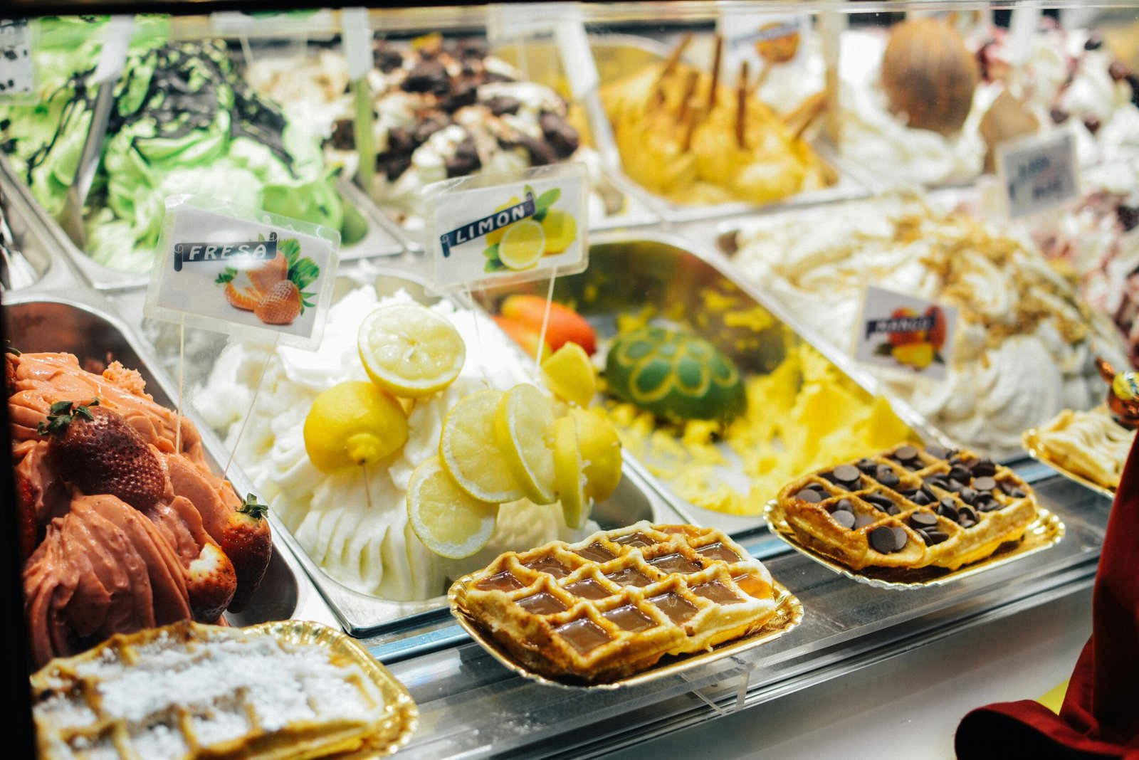 Brightly colored gelato and waffle selection at a Barcelona dessert shop.